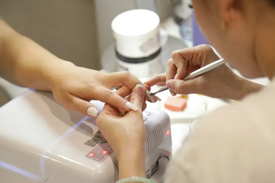 Technician shaping a gel manicure